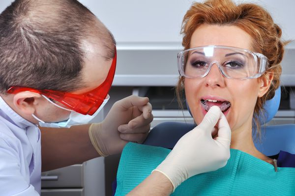 دندانپزشک دختر جوان آتل دندانی را امتحان می کند
