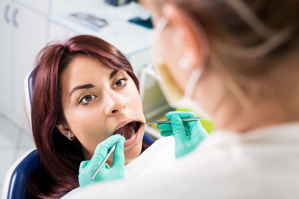 دندانپزشک در حال بررسی بهداشت دندان بیمار در مطب تمرکز انتخابی تمرکز بر بیمار