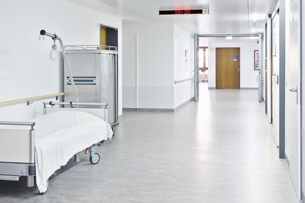 راهرو با تخت سفید در بیمارستان با واگن برقی