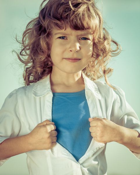 کودک مانند یک ابرقهرمان پیراهن خود را باز می کند مفهوم قدرت دختر و فمینیسم