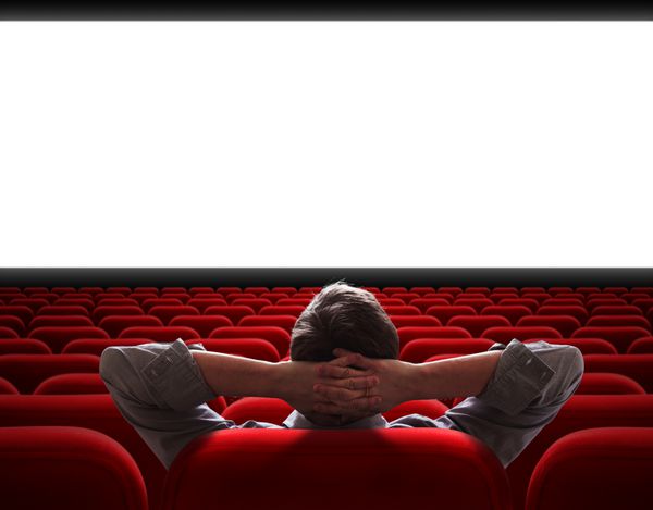 مردی که تنها در سالن خالی سینما نشسته است
