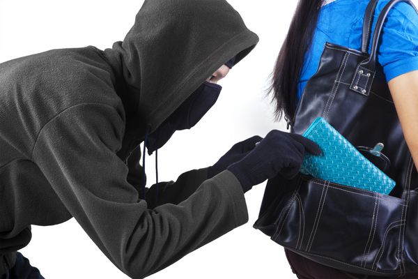 دزد در حال سرقت کیف پول از کیف دستی یک زن جدا شده در زمینه سفید