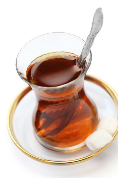چای ترکی در لیوان کوچک لاله شکل جدا شده در پس زمینه سفید