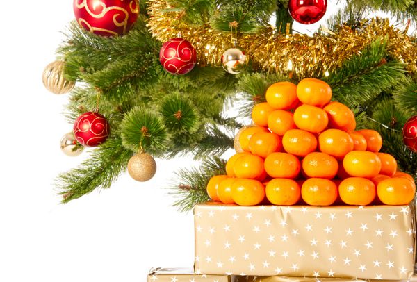 درخت کریسمس با هدایا و هدایا و نارنگی جدا شده روی سفید