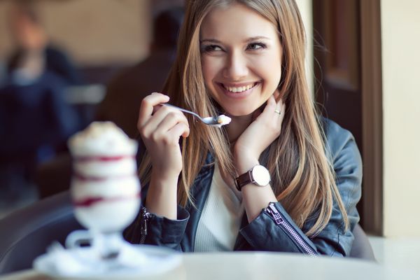 زن جوان زیبا در حال خوردن دسر