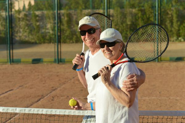 تنیس زن و شوهر مسن خوشبخت در فضای باز