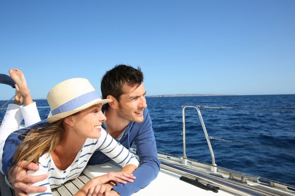 زوجی که از گشت و گذار با قایق بادبانی لذت می برند