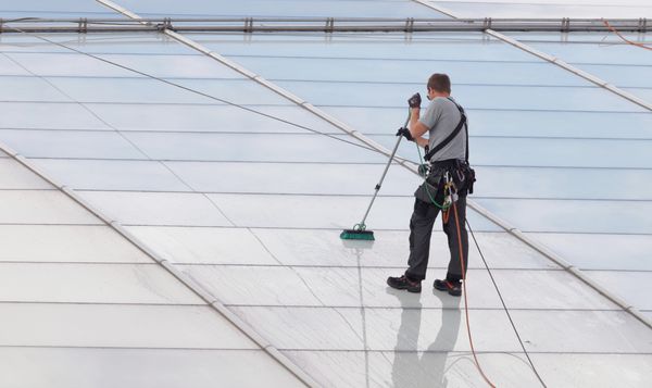 کارگران در حال شستن سقف شیشه ای یک ساختمان اداری مدرن