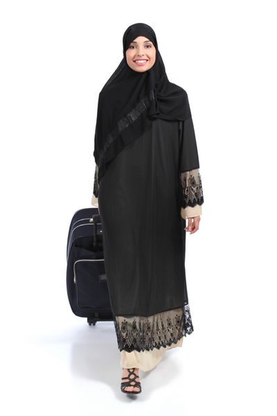تمام بدن یک مسافر زن عربستانی عرب که جدا شده روی پس‌زمینه سفید راه می‌رود