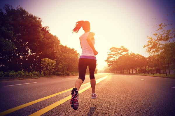 دونده ورزشکار در حال دویدن در جاده تناسب اندام زن طلوع آفتاب ورزش آهسته دویدن مفهوم سلامتی