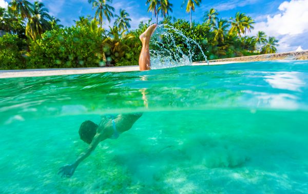 زن در حال شنا در زیر آب غواصی در دریای شفاف فیروزه ای طبیعت گرمسیری فوق العاده ماجراجویی تابستانی و مفهوم گردشگری