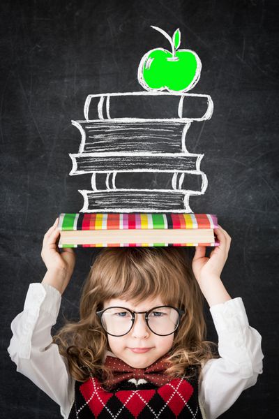 بچه باهوش در کتابخانه کودک شاد در برابر تخته سیاه مفهوم آموزش و پرورش