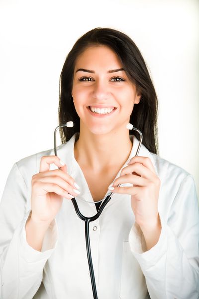 زن زیبا پزشک زن شاد و خندان گوشی پزشکی حرفه ای در دست دارد که روی پس زمینه سفید جدا شده است مفهوم تعامل پزشک و بیمار