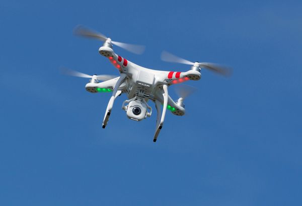 meerkerk هلند - 18 مه 2014 po پهپاد کوادروکوپتر dji phantom fc-40 در حال پرواز در برابر آسمان آبی صنایع dji طیف وسیعی از UAVها را برای تفریح و تجارت تولید می کند