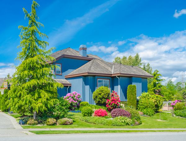 خانه لوکس سفارشی ساخته شده با حیاط جلویی زیبا و محوطه سازی شده و راه ورودی به گاراژ دو درب در محله مسکونی ونکوور کانادا
