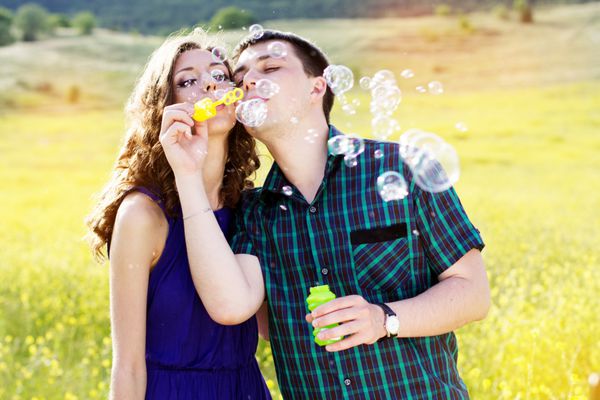 زوج جوان با دمنده حباب بازی می کنند
