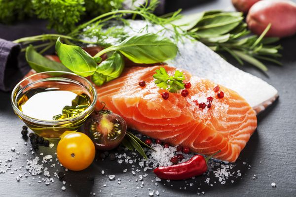 قسمت خوشمزه فیله ماهی قزل آلا تازه با گیاهان معطر ادویه جات و سبزیجات - غذای سالم رژیم غذایی یا مفهوم آشپزی