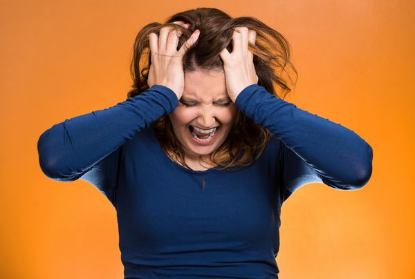 پرتره نزدیک زن تاجری با استرس موهایش را بیرون می‌کشد فریاد می‌کشد با پس‌زمینه نارنجی پرخاشگرانه فریاد می‌زند احساسات منفی انسانی حالات چهره نگرش واکنش