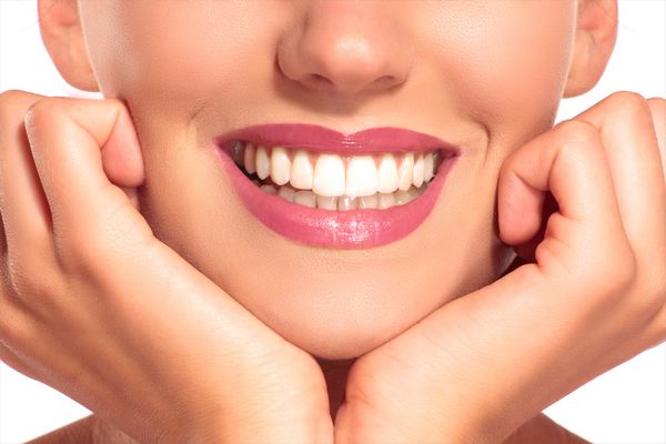 نمای نزدیک از زن خندان با دندان های سفید کامل روی سفید