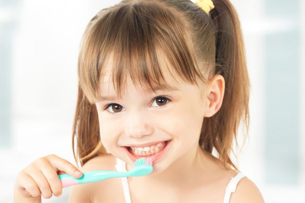 بهداشت دندان دختر بچه خوشحالی که مسواک میزنه