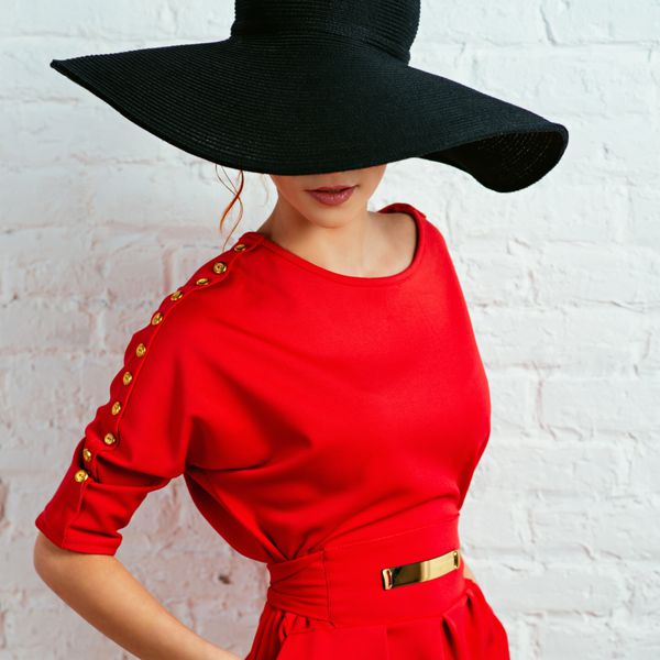 زن جوان شیک پوش زیبا با لباس قرمز و کلاه مشکی سبک مد po با فیلترهای استایل اینستاگرام