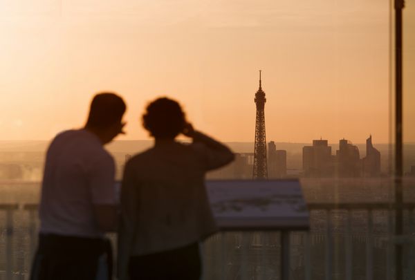 زوج عاشق در پاریس برج ایفل را در غروب آفتاب تحسین می کنند