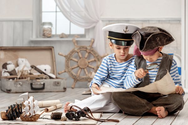 دو پسر یک کاپیتان دزد دریایی نقشه سفر را در اتاقش می خواند