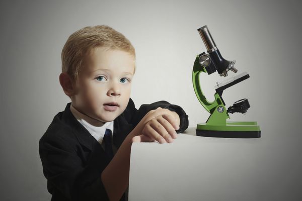 کودک بامزه دانشمند کوچولو پرتره مد پسر کوچولو با کراوات پسر مدرسه ای که با میکروسکوپ کار می کند بچه باهوش آموزش