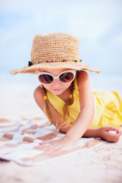 دختر کوچک شایان ستایش در ساحل در طول تعطیلات تابستانی