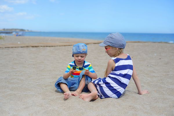 دو بچه در ساحل نشسته اند