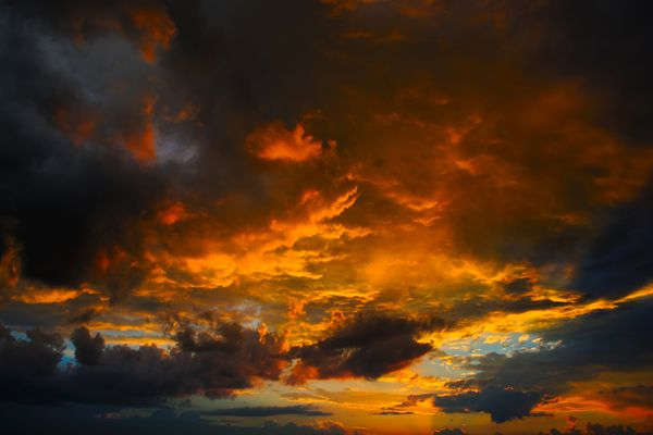 غروب آفتاب با ابرها در سایه های نارنجی و بنفش
