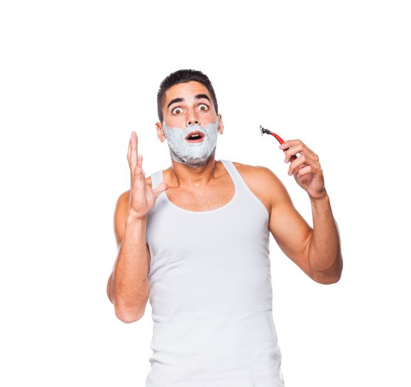مرد خوش تیپی که ریش خود را با تیغ می تراشد در زمینه سفید