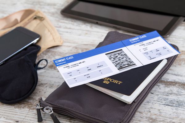 بلیط هواپیما گذرنامه و لوازم الکترونیکی آماده شدن برای سفر