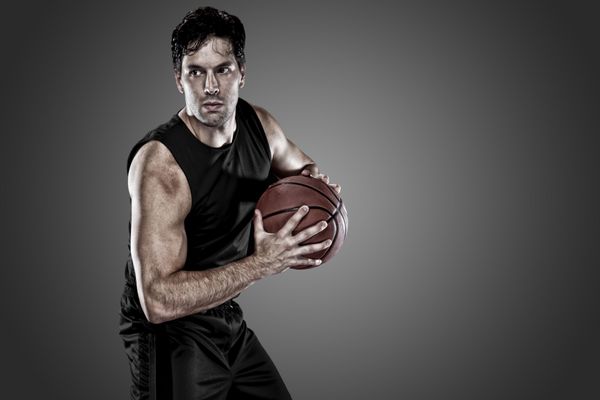 بازیکن بسکتبال در یک لباس مشکی در زمینه سیاه