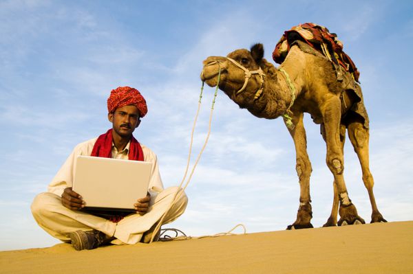 مرد بومی هندی با لپ تاپش در بیابان