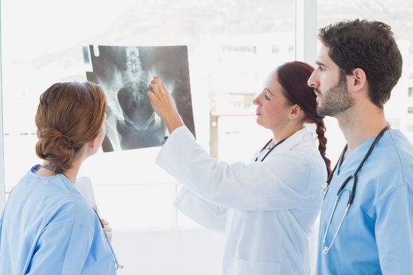 دکتر در حال گرفتن عکس اشعه ایکس با پزشکان دیگر