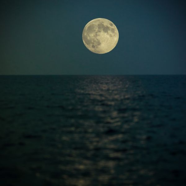 ابر ماه کامل در زیر دریا که بازتاب نور را روی آب می گیرد