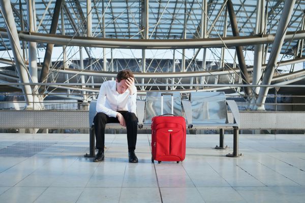 مشکل در فرودگاه مرد خسته با چمدان در ترمینال منتظر است