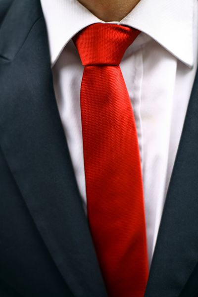 مرد تجاری با کت و شلوار با کراوات قرمز جزئیات روی کراوات