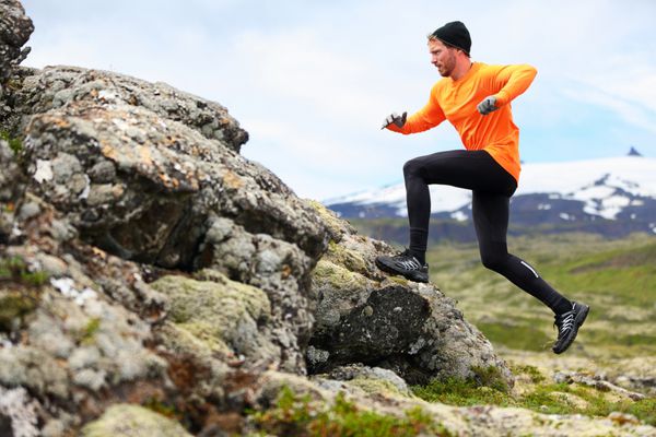 مرد دونده ورزشی در تریل کانتری تمرین ورزشی دونده مرد مناسب و پرش در فضای باز در منظره طبیعت کوهستانی زیبا با اسنافلزجوکل اسنافلزنس ایسلند