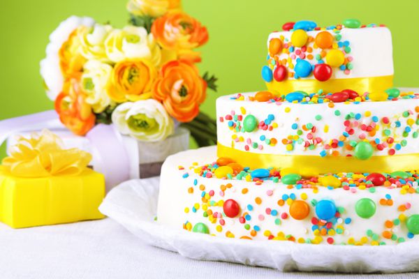 کیک تولد خوش طعم و کادو در پس زمینه رنگی