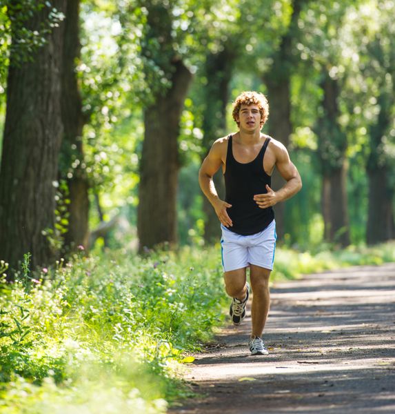 مرد جوانی که در فضای باز در پارک می دود