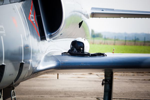 جزئیات موتور جت هواپیمای رهگیر جنگنده نظامی و بال با ماسک اکسیژن خلبان و کلاه ایمنی دراز کشیده آماده برخاستن در صورت حمله تروریستی تصویر رنگارنگ