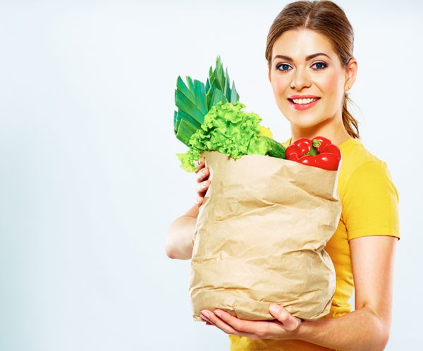 سبک زندگی سالم با غذاهای گیاهی سبز زن جوان کیسه خرید با سبزیجات در دست دارد