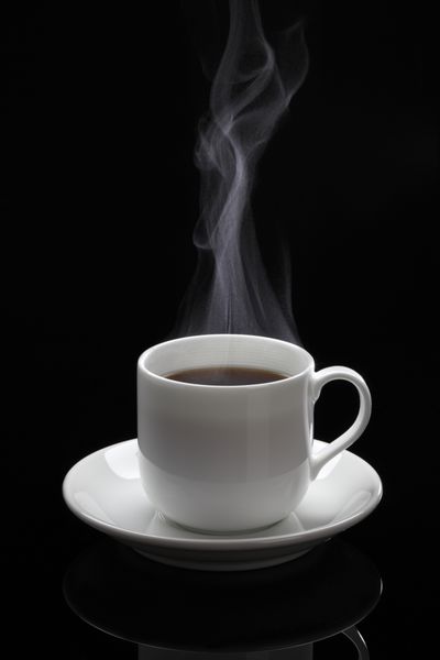 فنجان قهوه سیاه فنجان قهوه سیاه با بخار در پس زمینه سیاه