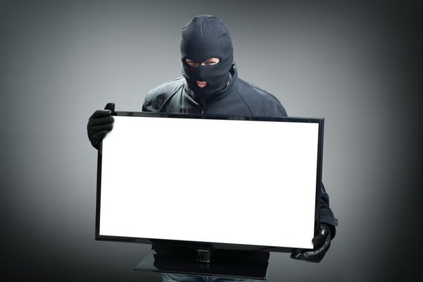 دزد در حال سرقت مانیتور کامپیوتر یا مفهوم تلویزیون برای هکر امنیت یا بیمه با sp روی صفحه برای پیام