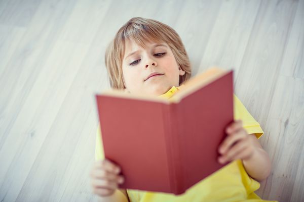 پسر بچه در حال خواندن کتاب