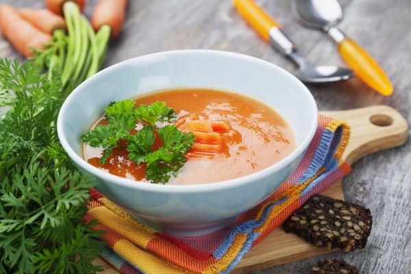 سوپ هویج در کاسه آبی روی میز