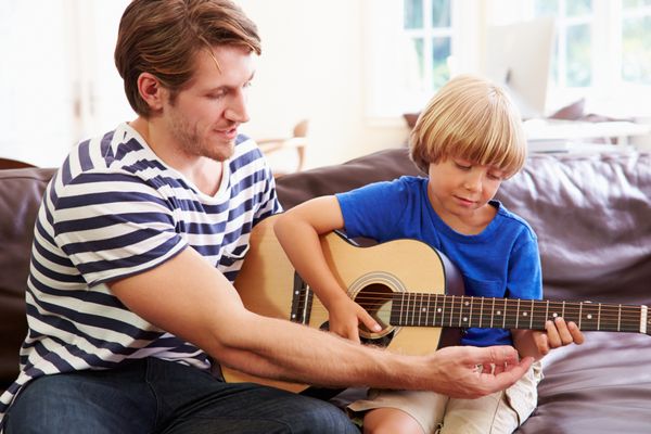 پدر به پسرش نواختن گیتار را آموزش می دهد