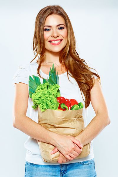 سبک زندگی سالم با غذاهای گیاهی سبز زن جوان کیسه خرید با سبزیجات در دست دارد